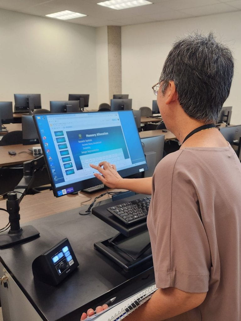 Instructor touching computer screen in a TEC.